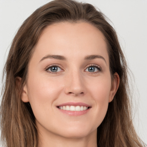 Joyful white young-adult female with long  brown hair and grey eyes