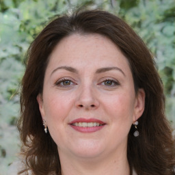 Joyful white adult female with long  brown hair and brown eyes