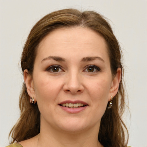 Joyful white adult female with medium  brown hair and green eyes