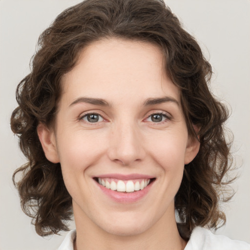 Joyful white young-adult female with medium  brown hair and green eyes