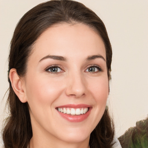 Joyful white young-adult female with long  brown hair and brown eyes