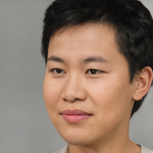 Joyful asian young-adult male with short  brown hair and brown eyes