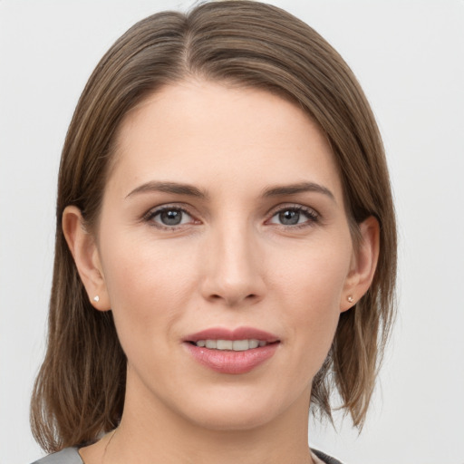 Joyful white young-adult female with medium  brown hair and grey eyes