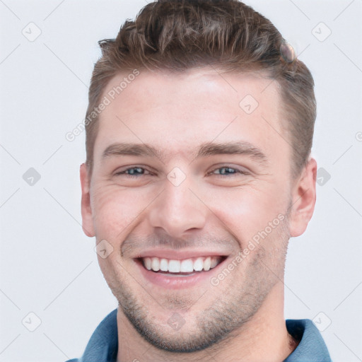 Joyful white young-adult male with short  brown hair and grey eyes