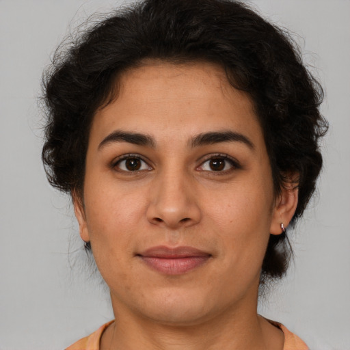 Joyful latino young-adult female with medium  brown hair and brown eyes
