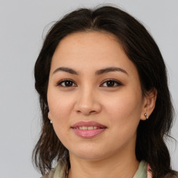 Joyful latino young-adult female with medium  brown hair and brown eyes