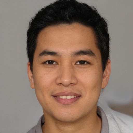 Joyful white young-adult male with short  black hair and brown eyes