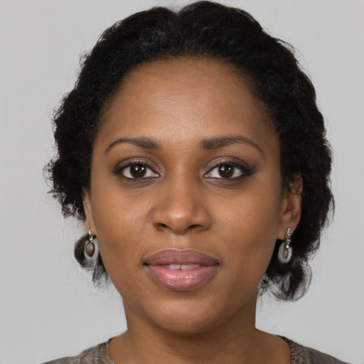 Joyful black adult female with medium  brown hair and brown eyes