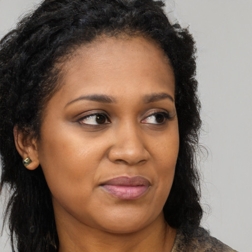 Joyful black young-adult female with long  brown hair and brown eyes