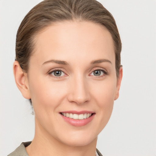 Joyful white young-adult female with medium  brown hair and grey eyes