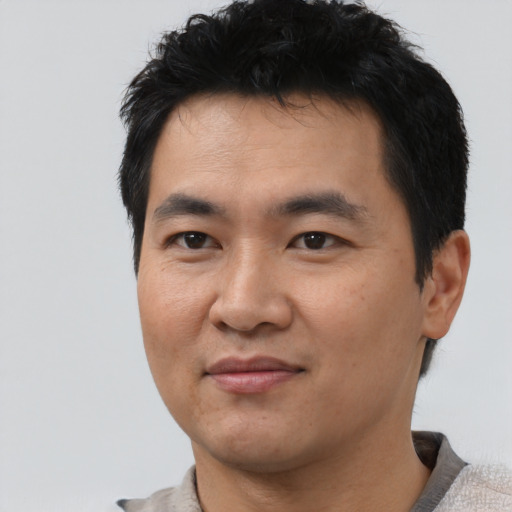 Joyful asian young-adult male with short  black hair and brown eyes