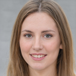 Joyful white young-adult female with long  brown hair and green eyes