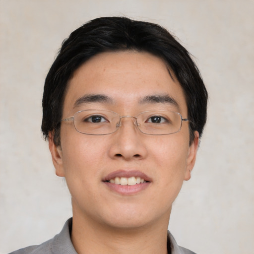 Joyful asian young-adult male with short  black hair and brown eyes