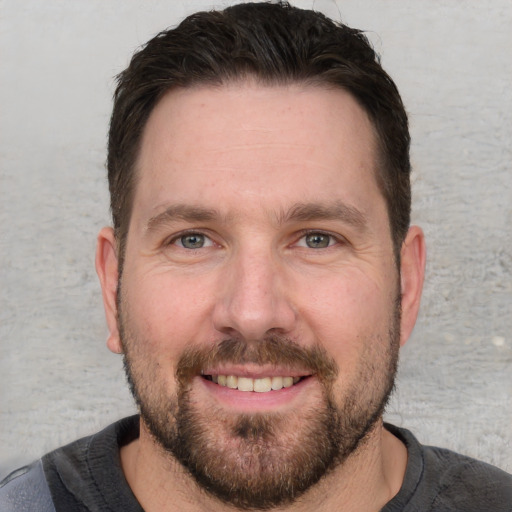 Joyful white adult male with short  brown hair and grey eyes