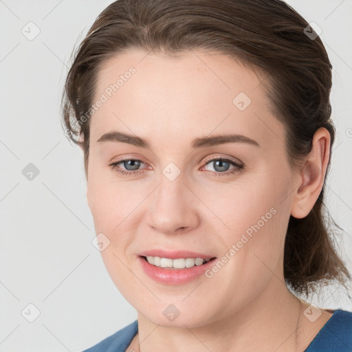 Joyful white young-adult female with medium  brown hair and grey eyes