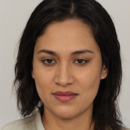 Joyful latino young-adult female with long  brown hair and brown eyes