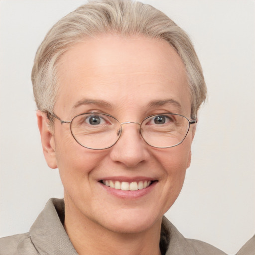 Joyful white middle-aged female with short  blond hair and blue eyes