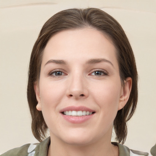 Joyful white young-adult female with medium  brown hair and grey eyes