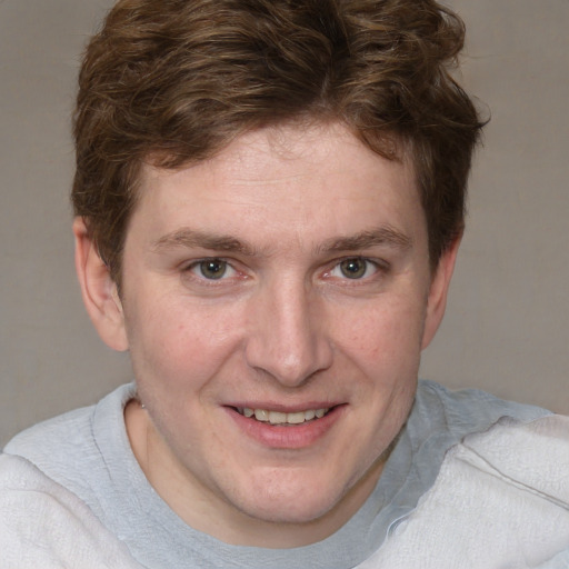 Joyful white young-adult male with short  brown hair and blue eyes