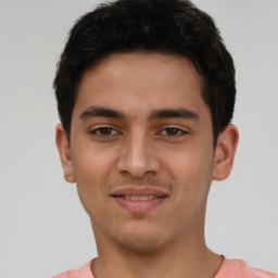 Joyful latino young-adult male with short  black hair and brown eyes