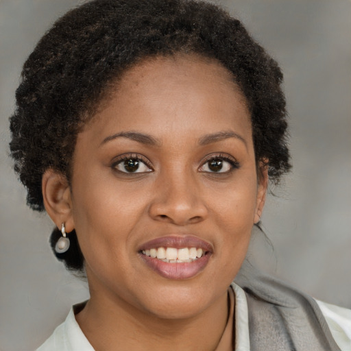 Joyful black young-adult female with short  brown hair and brown eyes