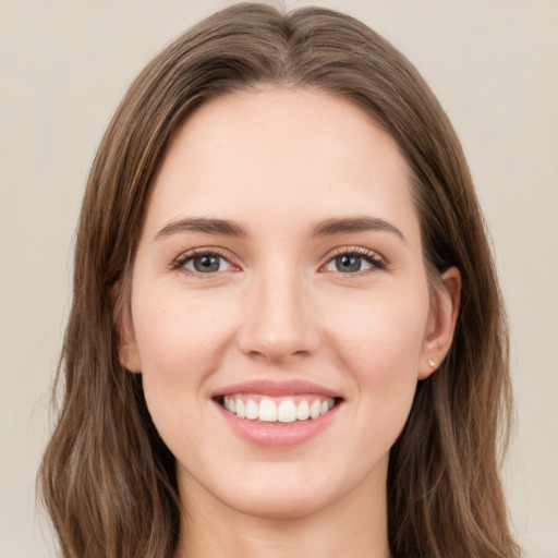 Joyful white young-adult female with long  brown hair and green eyes