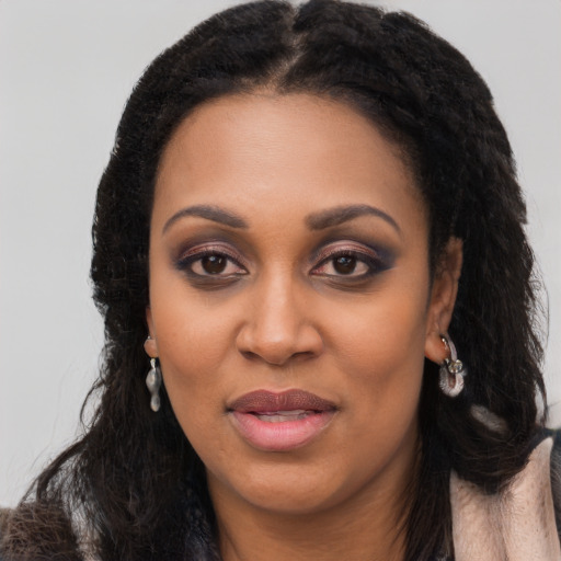 Joyful black young-adult female with long  black hair and brown eyes