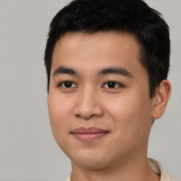 Joyful asian young-adult male with short  black hair and brown eyes