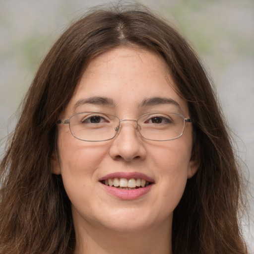 Joyful white adult female with long  brown hair and grey eyes