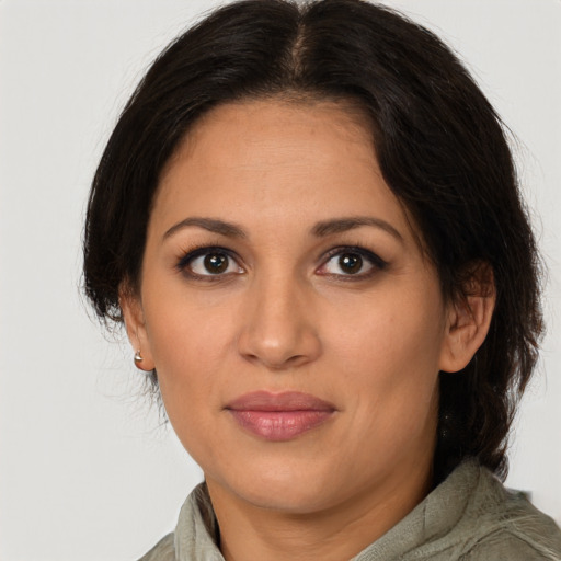 Joyful latino adult female with medium  brown hair and brown eyes