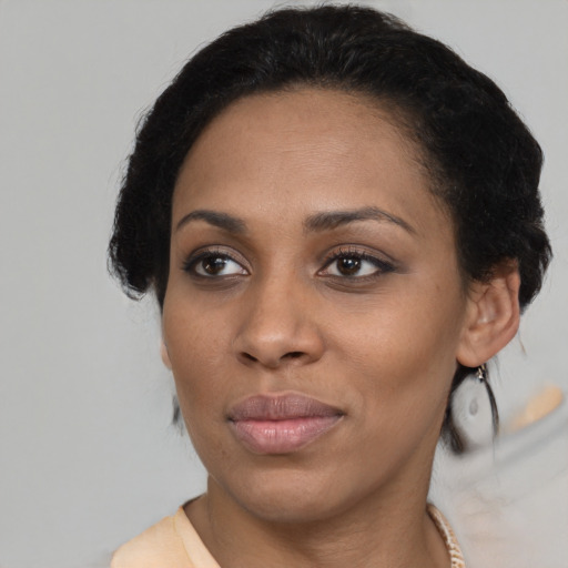 Joyful black young-adult female with medium  black hair and brown eyes