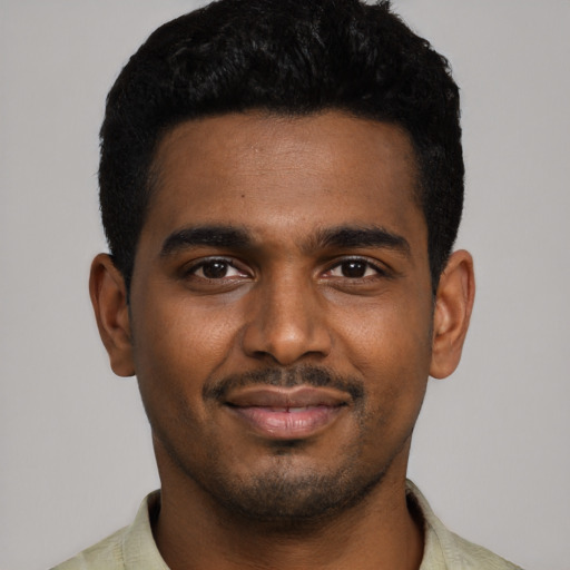 Joyful black young-adult male with short  black hair and brown eyes