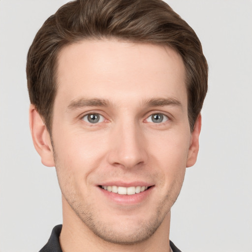 Joyful white young-adult male with short  brown hair and grey eyes