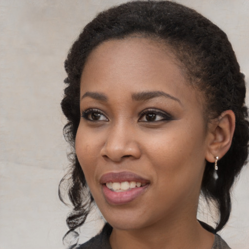 Joyful black young-adult female with medium  brown hair and brown eyes