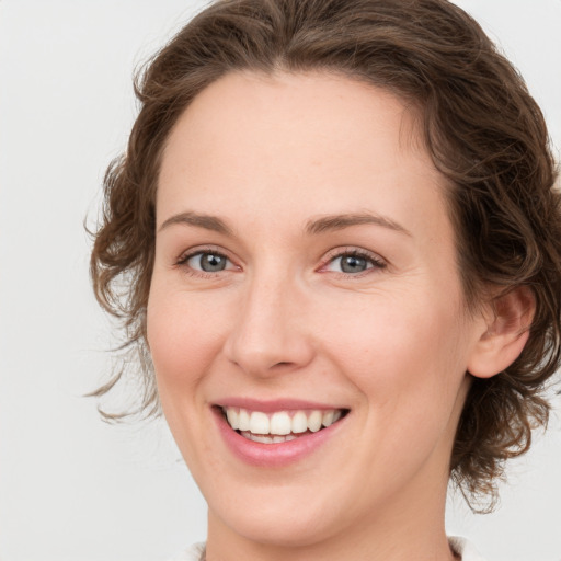 Joyful white young-adult female with medium  brown hair and green eyes