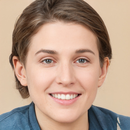 Joyful white young-adult female with short  brown hair and blue eyes