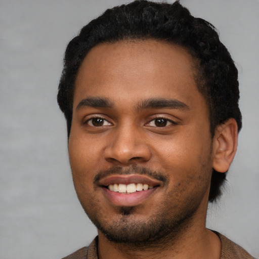 Joyful black young-adult male with short  black hair and brown eyes