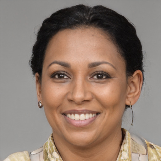 Joyful latino adult female with medium  brown hair and brown eyes