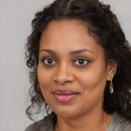 Joyful black young-adult female with long  brown hair and brown eyes