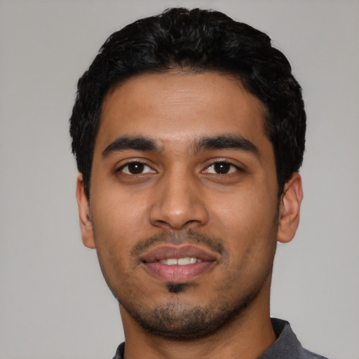 Joyful latino young-adult male with short  black hair and brown eyes
