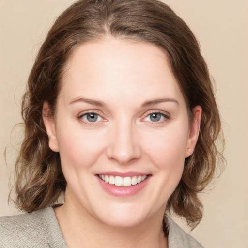 Joyful white young-adult female with medium  brown hair and green eyes