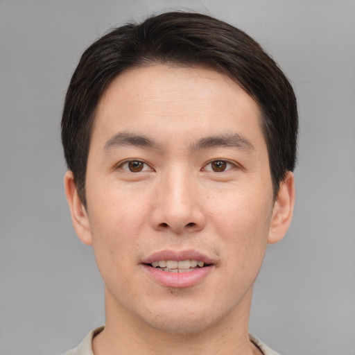 Joyful asian young-adult male with short  brown hair and brown eyes