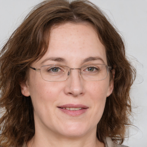 Joyful white adult female with medium  brown hair and grey eyes