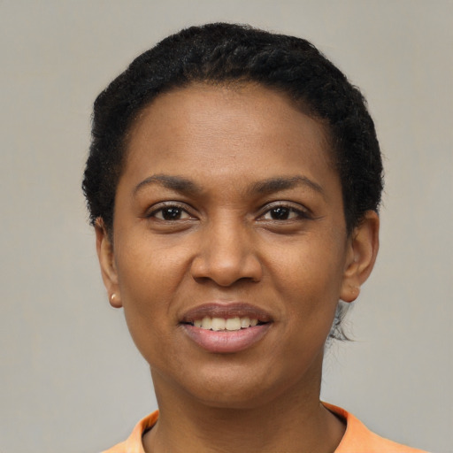 Joyful black young-adult female with short  black hair and brown eyes