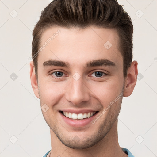 Joyful white young-adult male with short  brown hair and grey eyes