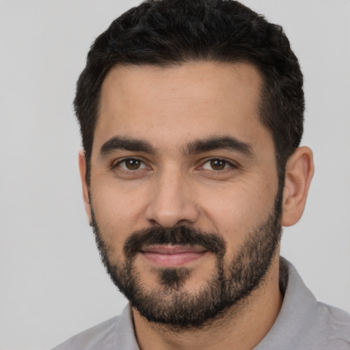 Joyful latino young-adult male with short  black hair and brown eyes