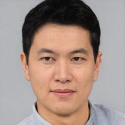 Joyful asian young-adult male with short  black hair and brown eyes