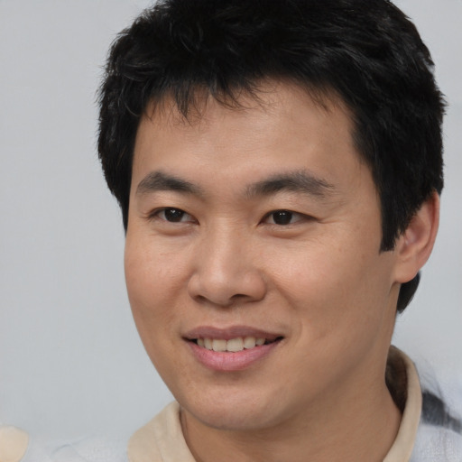 Joyful asian young-adult male with short  brown hair and brown eyes