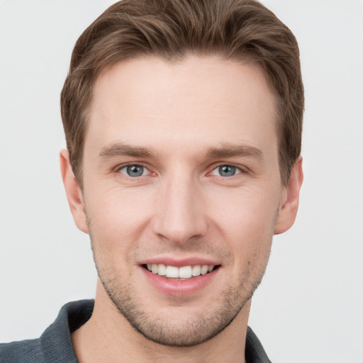 Joyful white young-adult male with short  brown hair and grey eyes