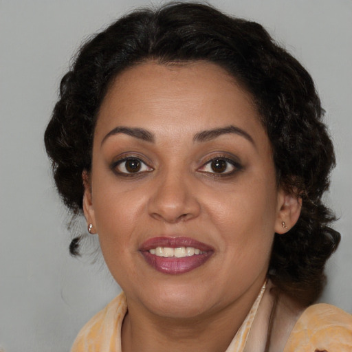 Joyful latino adult female with medium  brown hair and brown eyes